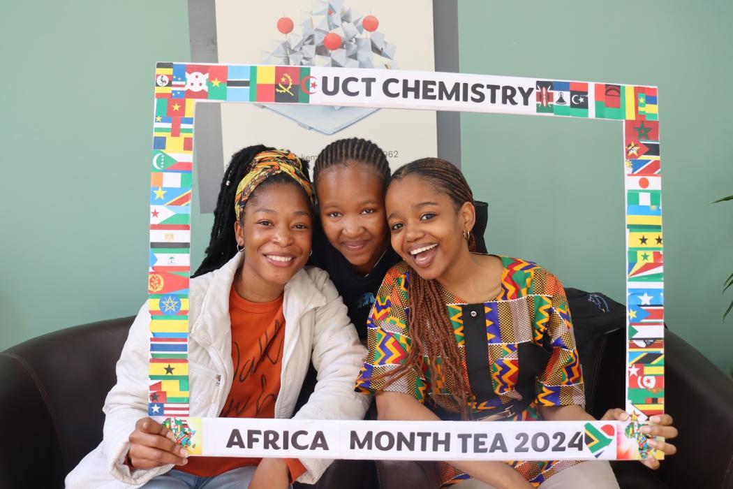 Postgraduate Students and Staff posing with the UCT Chemistry Africa Month Tea 2024 Banner