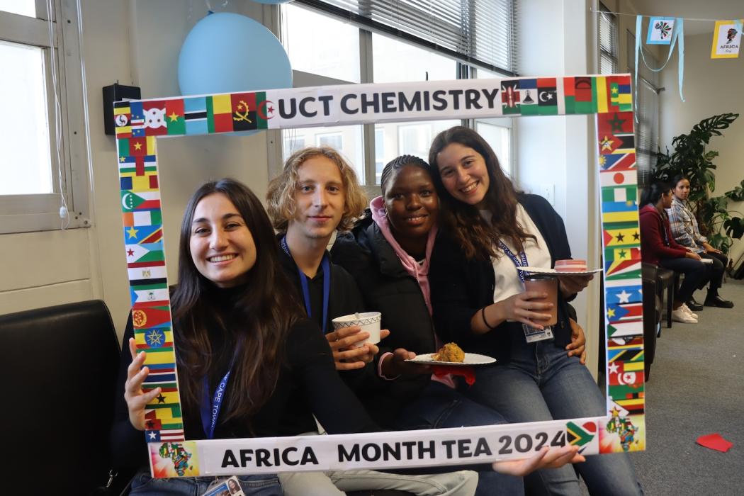Postgraduate Students and Staff posing with the UCT Chemistry Africa Month Tea 2024 Banner