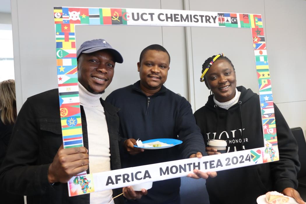Postgraduate Students and Staff posing with the UCT Chemistry Africa Month Tea 2024 Banner