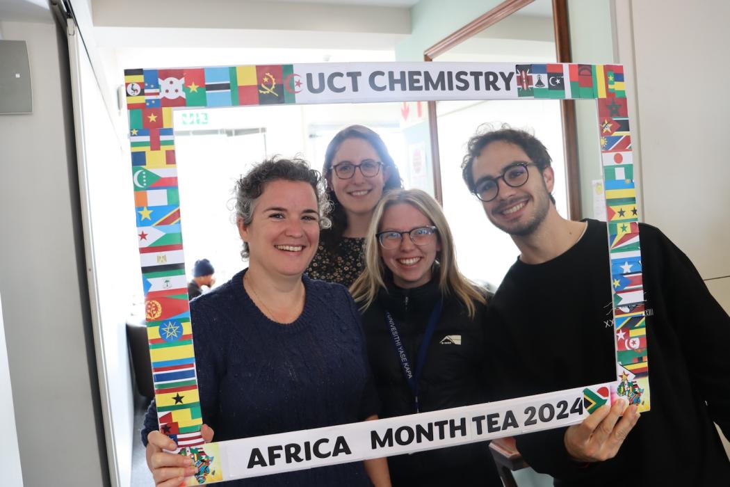 Postgraduate Students and Staff posing with the UCT Chemistry Africa Month Tea 2024 Banner