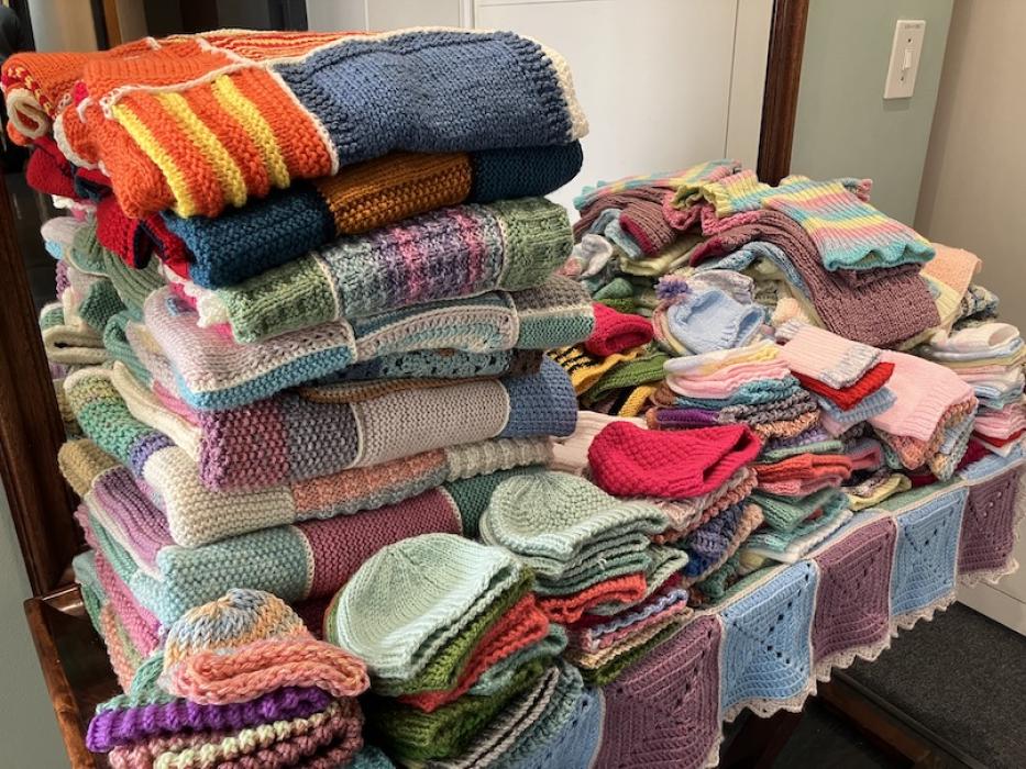 growing pile of knitted and crocheted folded items