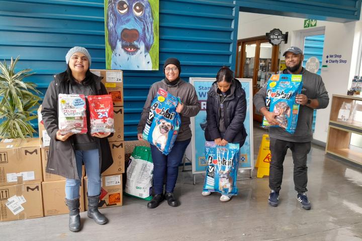Team holding food items for animals at the shelter