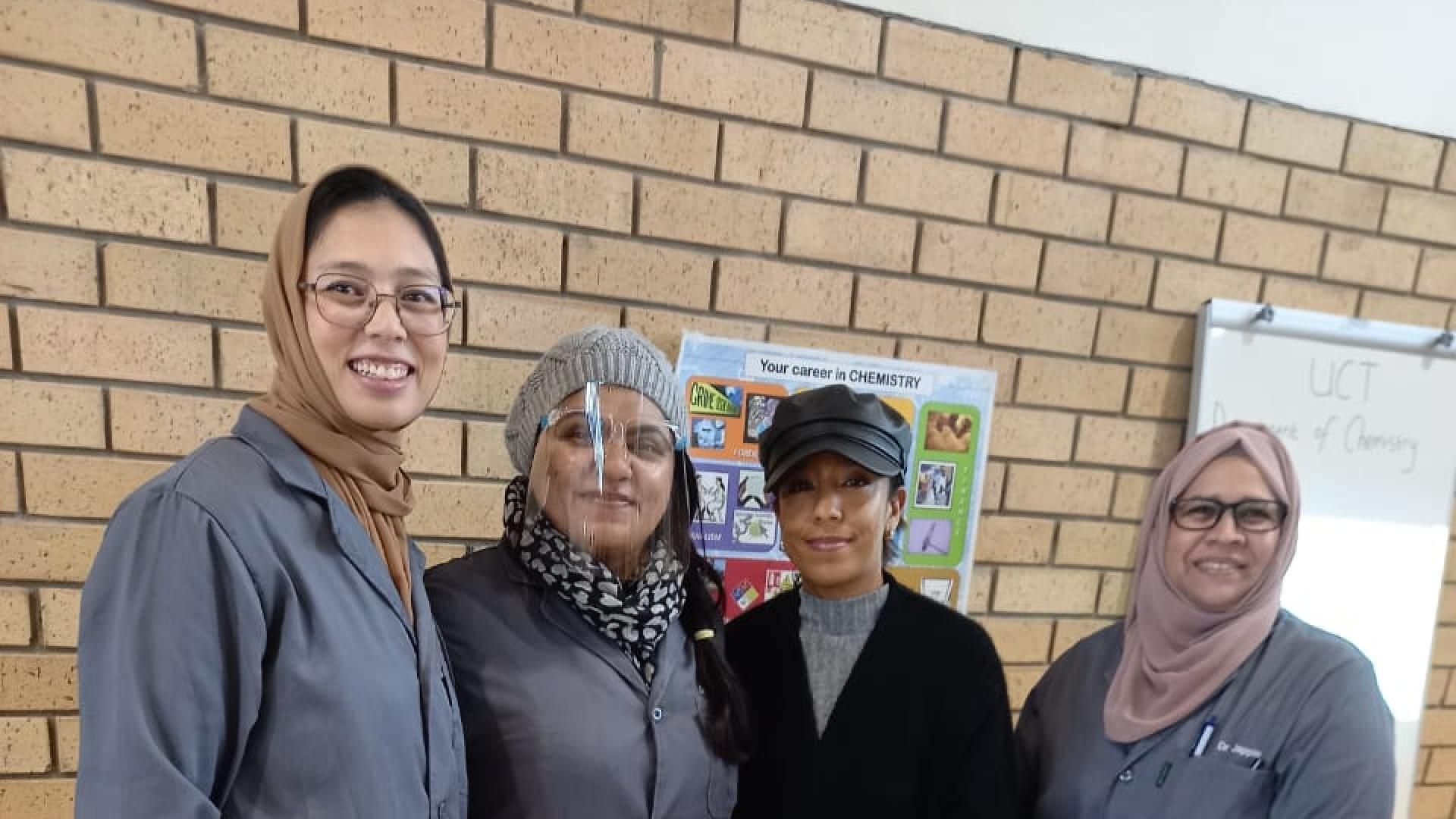 Four chemists posing in front of National Science Week 2023 exhibition table