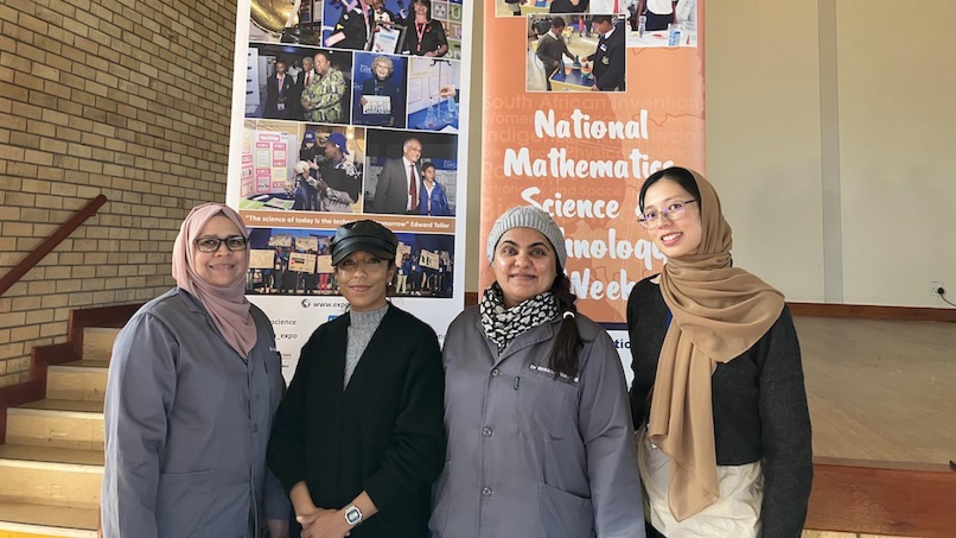 Four chemists posing in front of National Science Week 2023 poster