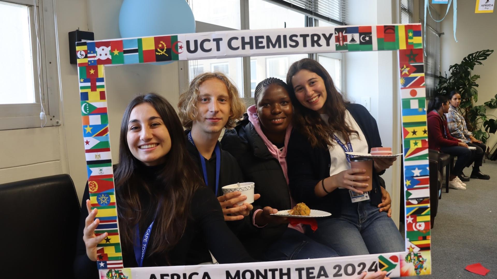 Postgraduate Students and Staff posing with the UCT Chemistry Africa Month Tea 2024 Banner