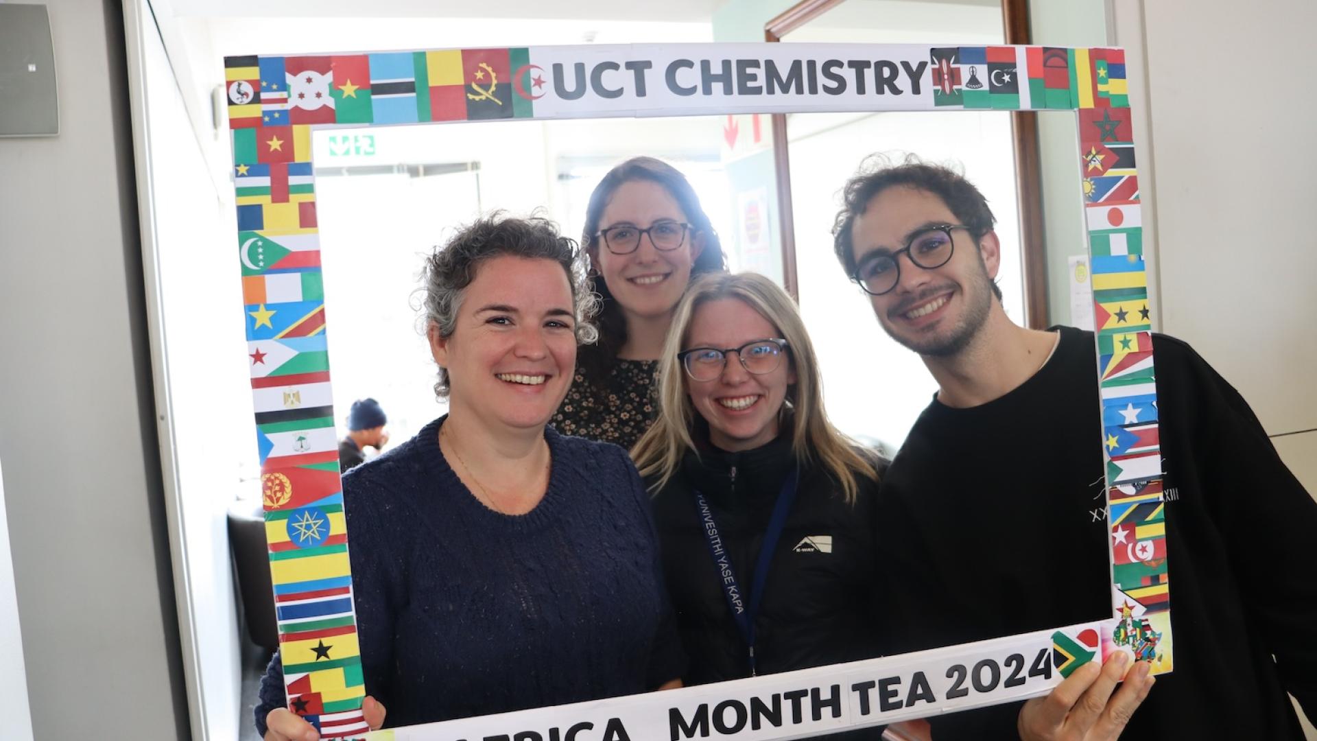 Postgraduate Students and Staff posing with the UCT Chemistry Africa Month Tea 2024 Banner