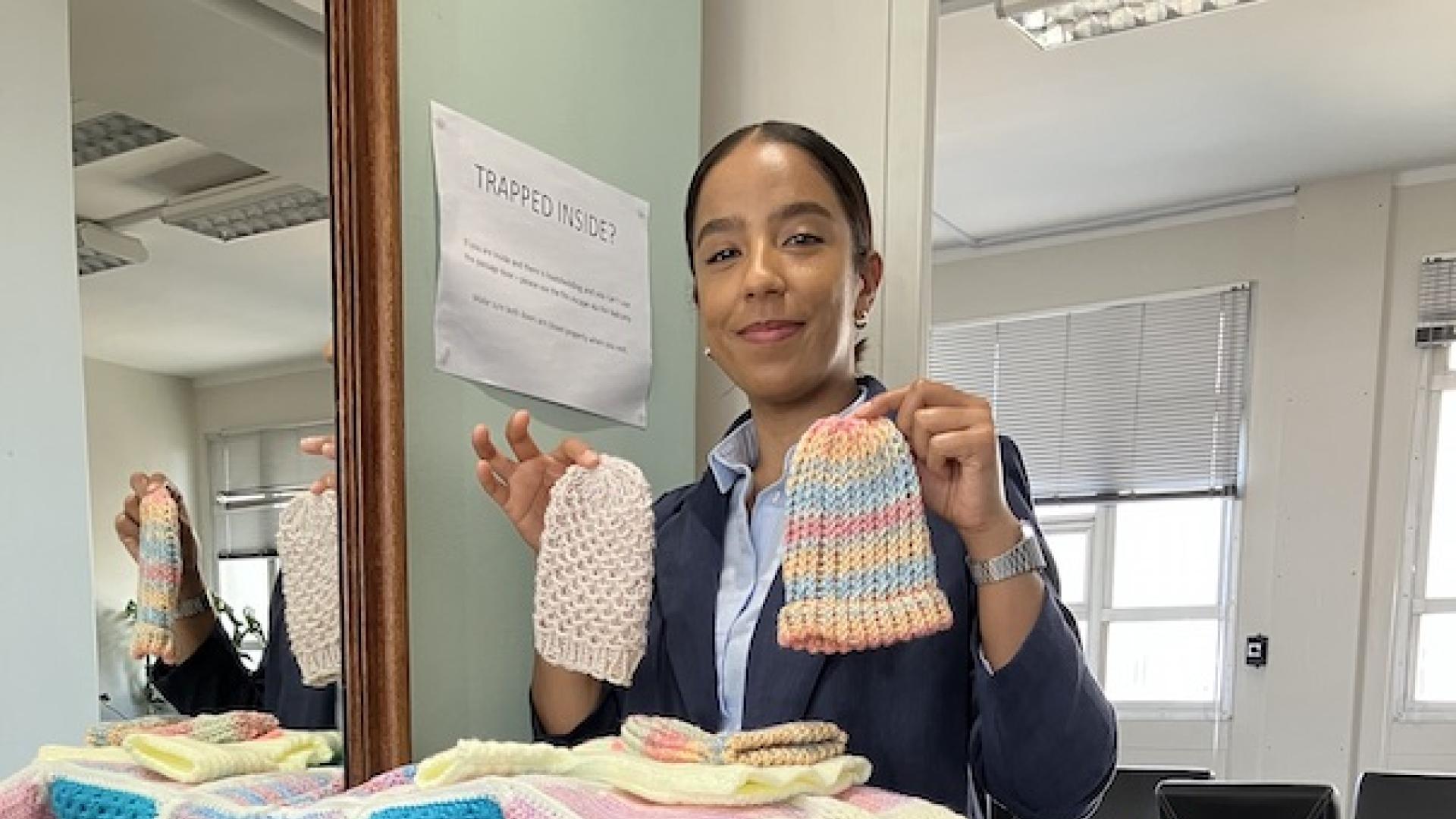 Samantha holding up beanies