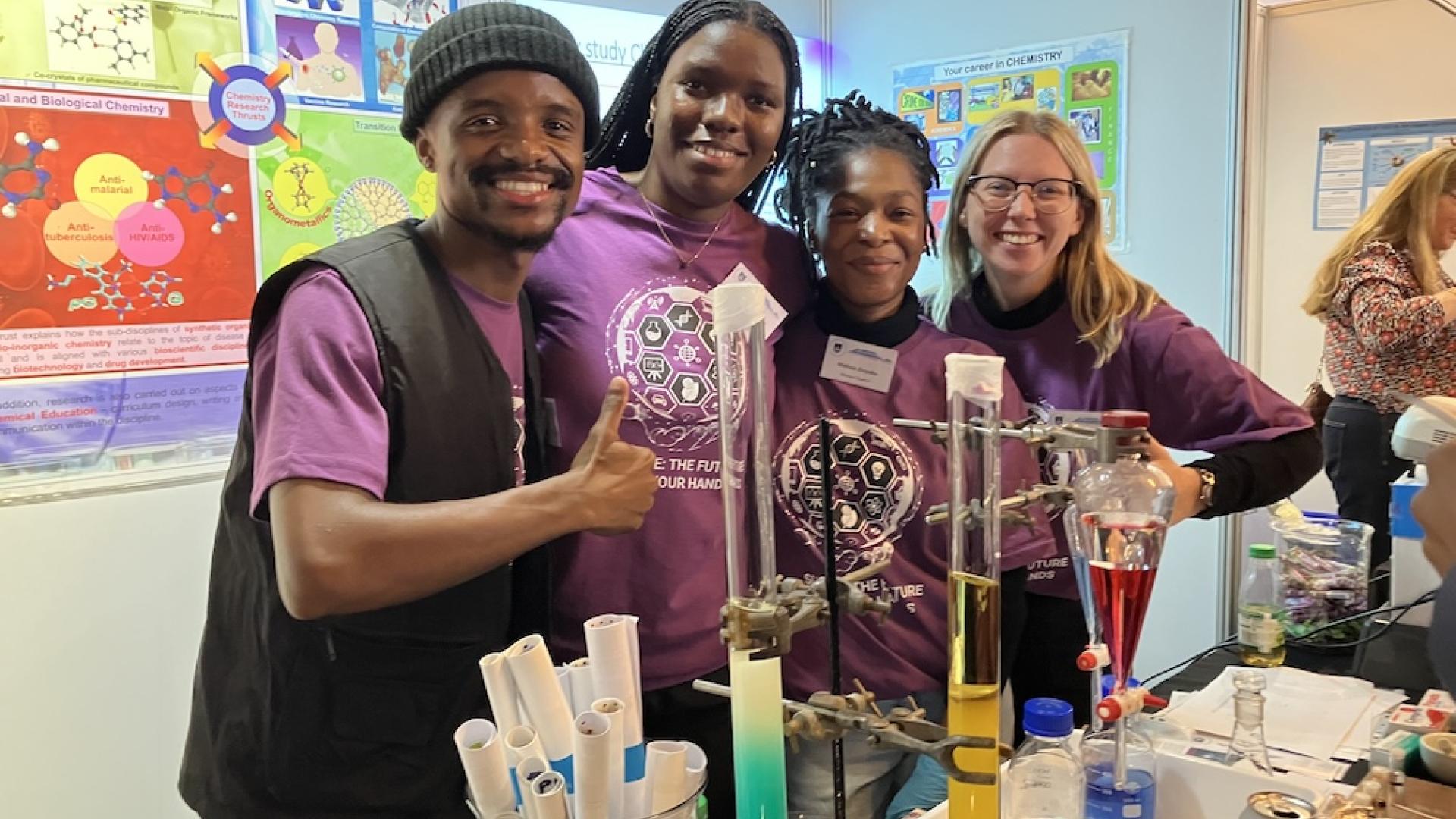 Postgraduate students pose for a picture at the chemistry exhibition table at UCT Open Day