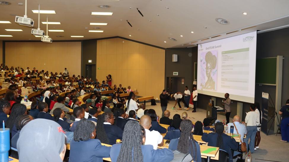People sitting in an auditorium watching a screen