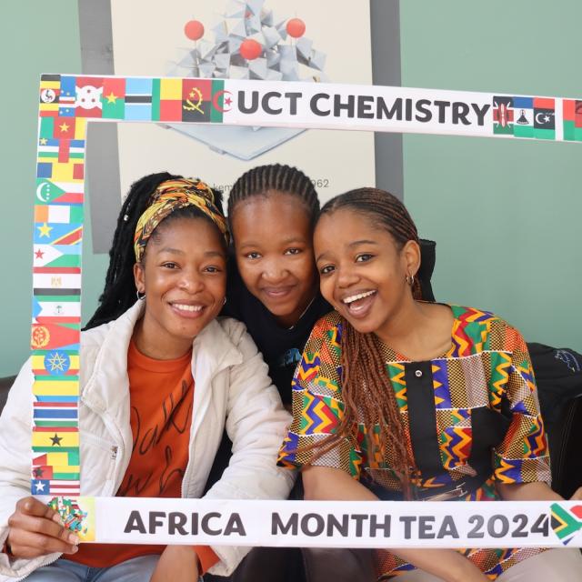 Postgraduate Students and Staff posing with the UCT Chemistry Africa Month Tea 2024 Banner