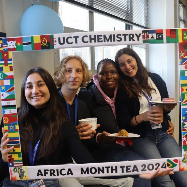 Postgraduate Students and Staff posing with the UCT Chemistry Africa Month Tea 2024 Banner