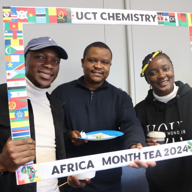 Postgraduate Students and Staff posing with the UCT Chemistry Africa Month Tea 2024 Banner
