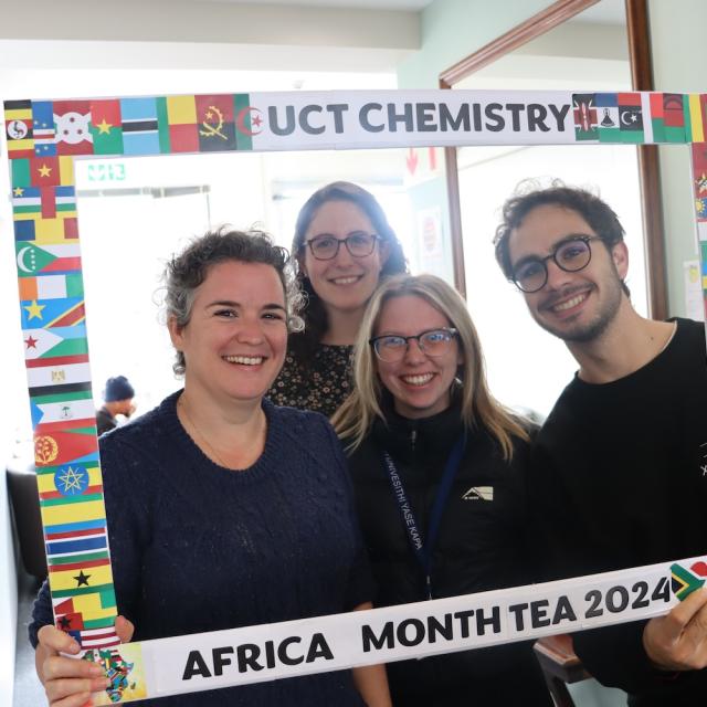 Postgraduate Students and Staff posing with the UCT Chemistry Africa Month Tea 2024 Banner