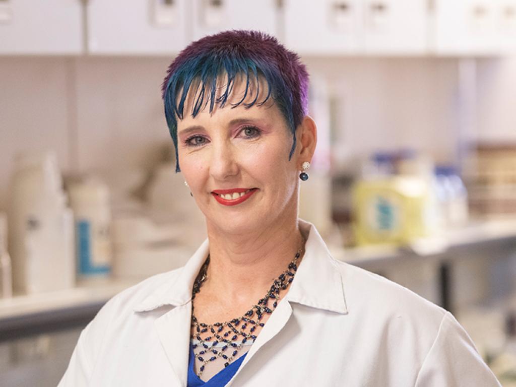 Ms Monique Muller with lab coat in chemistry laboratory.