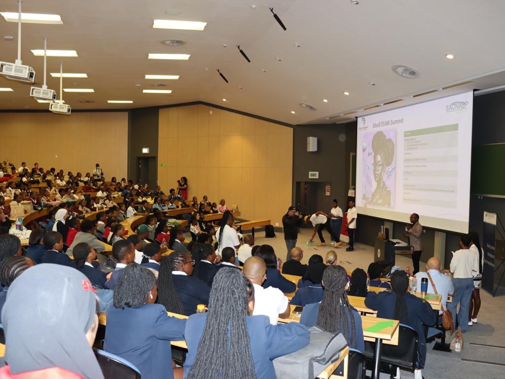 People sitting in an auditorium watching a screen